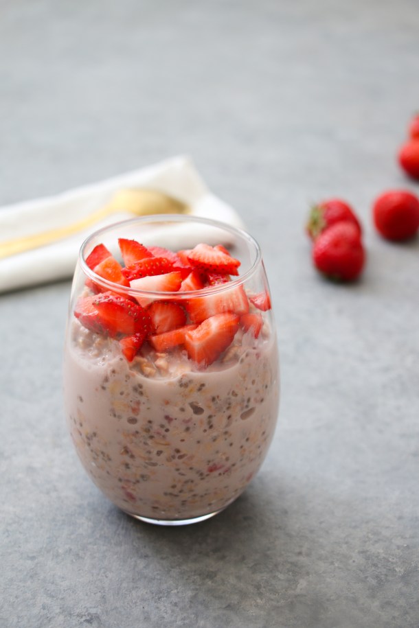 Strawberries and cream overnight oats in a glass jar.