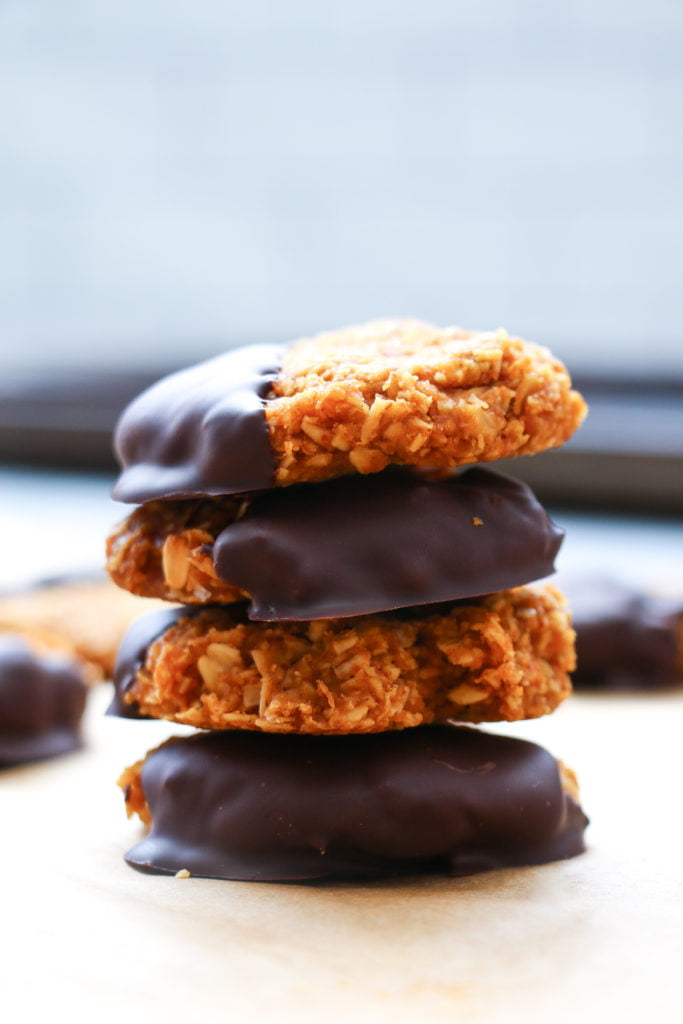 4 no-bake pumpkin and chocolate cookies stacked on top of each other on parchment paper.