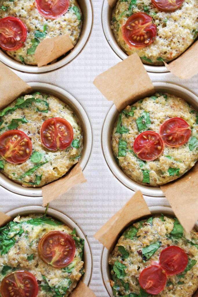 6 spinach and parmesan quinoa muffins in a gold muffin tin