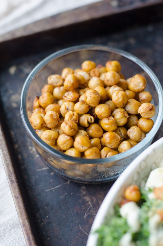 Chickpeas in a clear bowl on a black background.