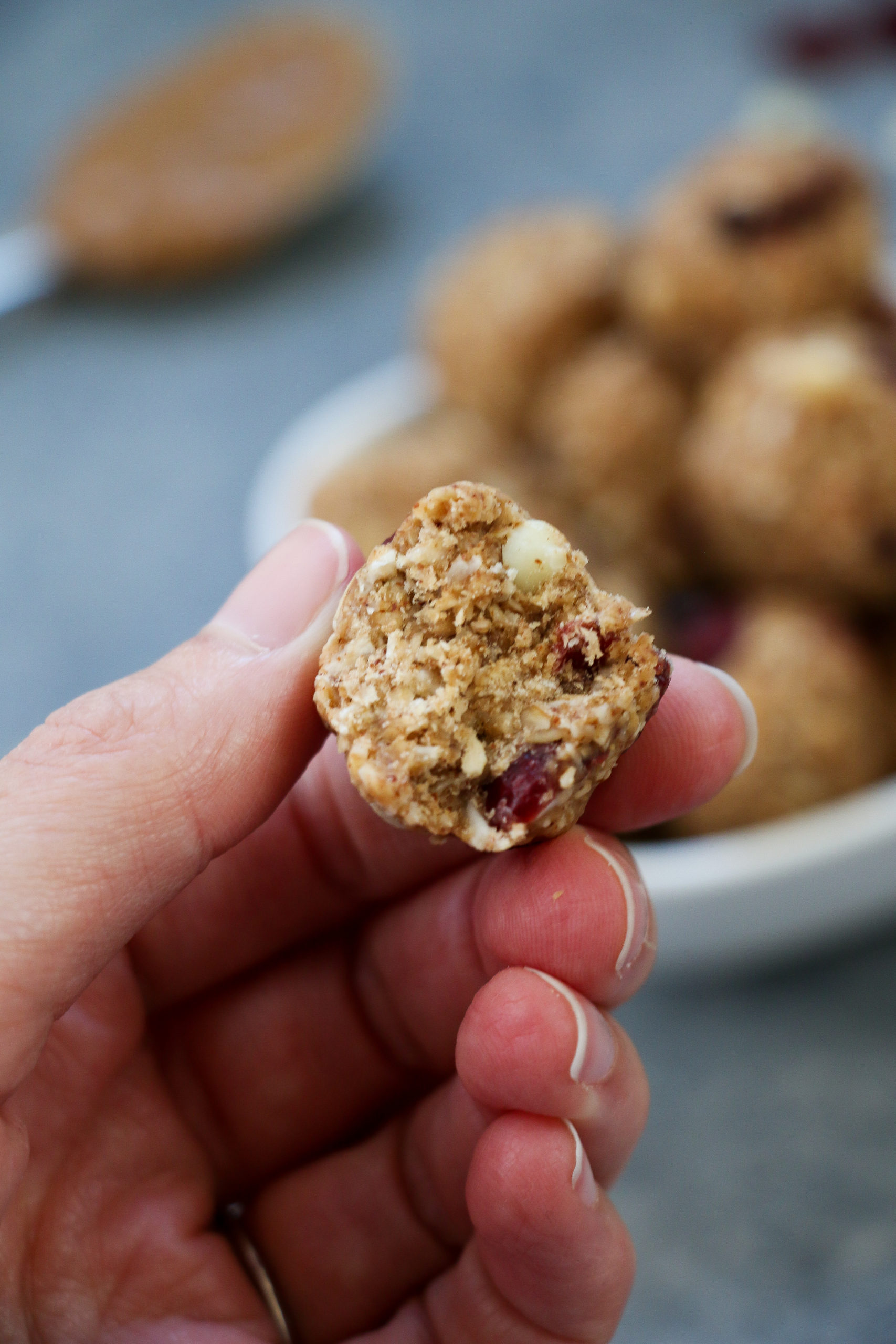 Close-up of white chocolate-cranberry energy bites against a gray background