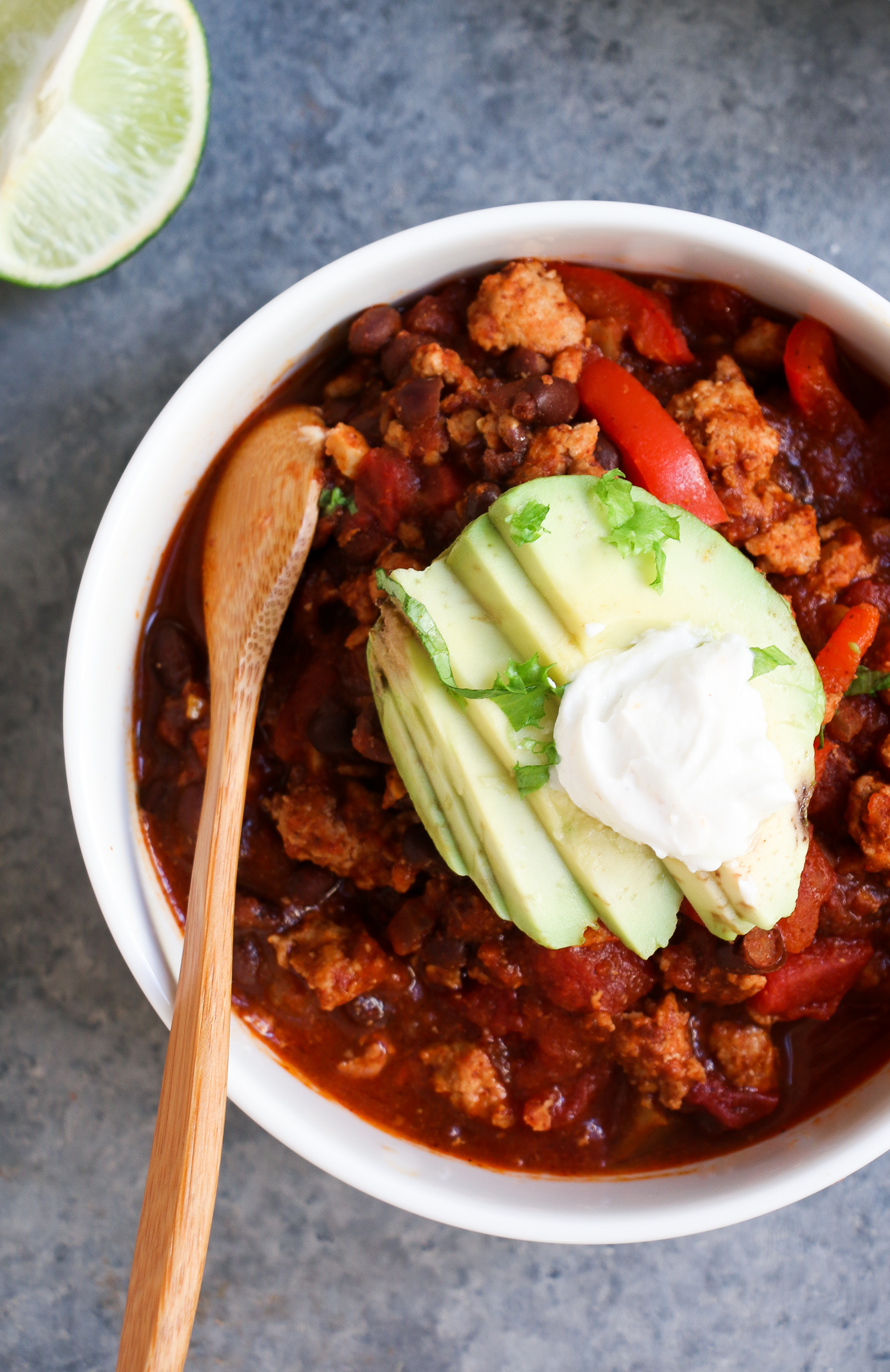 Overhead shot of easy turkey-black bean chili in a while bowl on a gray background